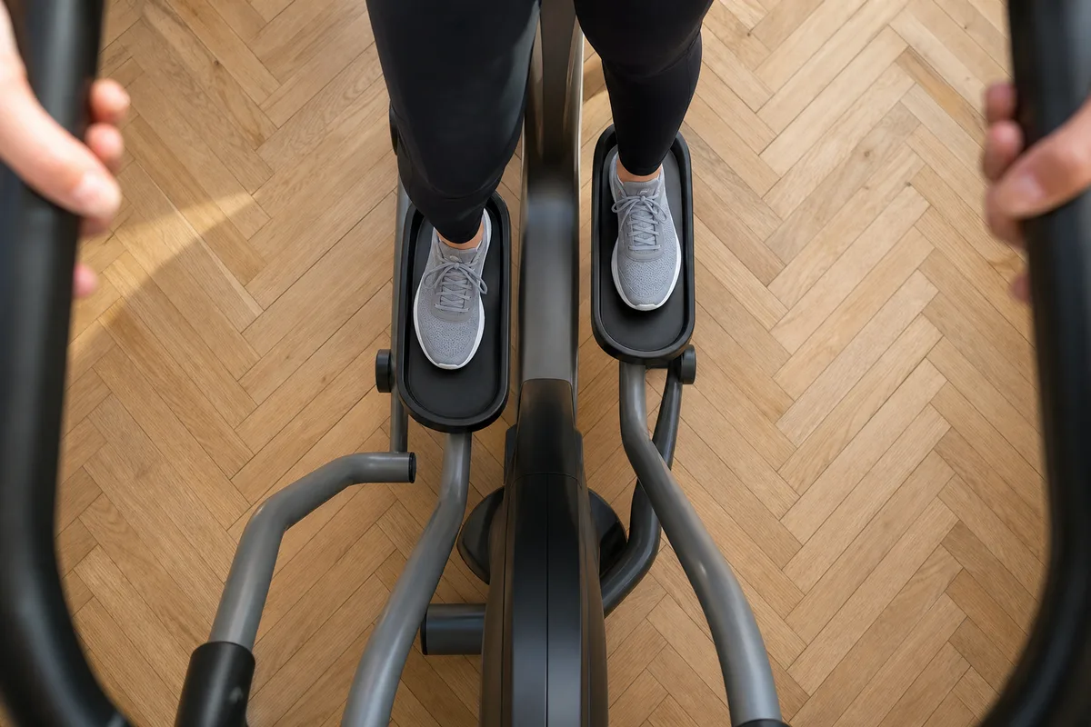 Chaussures de sport posées sur les pédales d&rsquo;un vélo elliptique, vue de dessus dans un intérieur en parquet